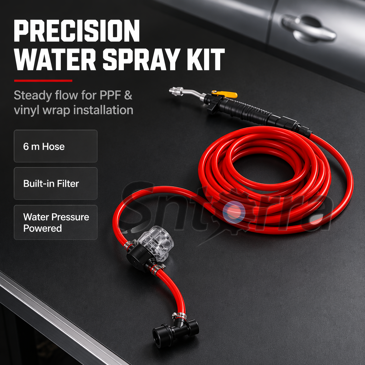 Red water hose and black spray gun in an automotive film workshop